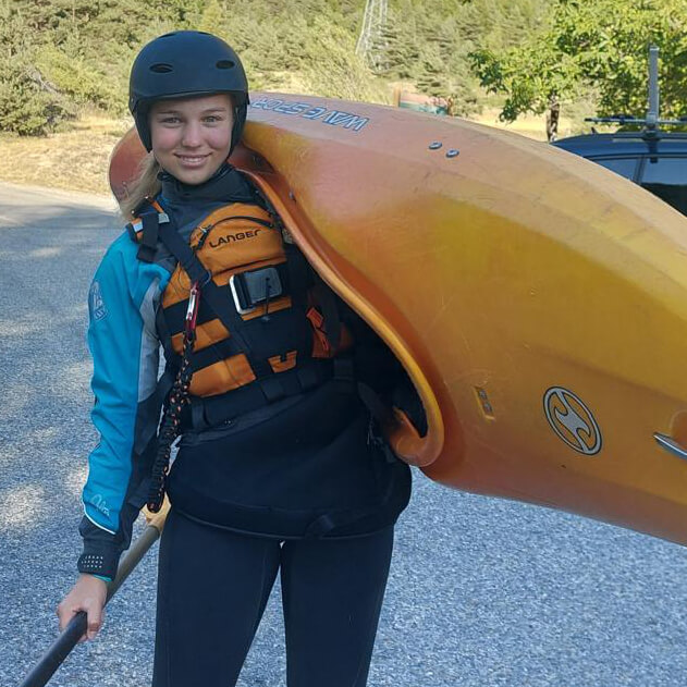 Leonie mit Kajak und Paddel in voller Ausrüstung mit Helm etc.
